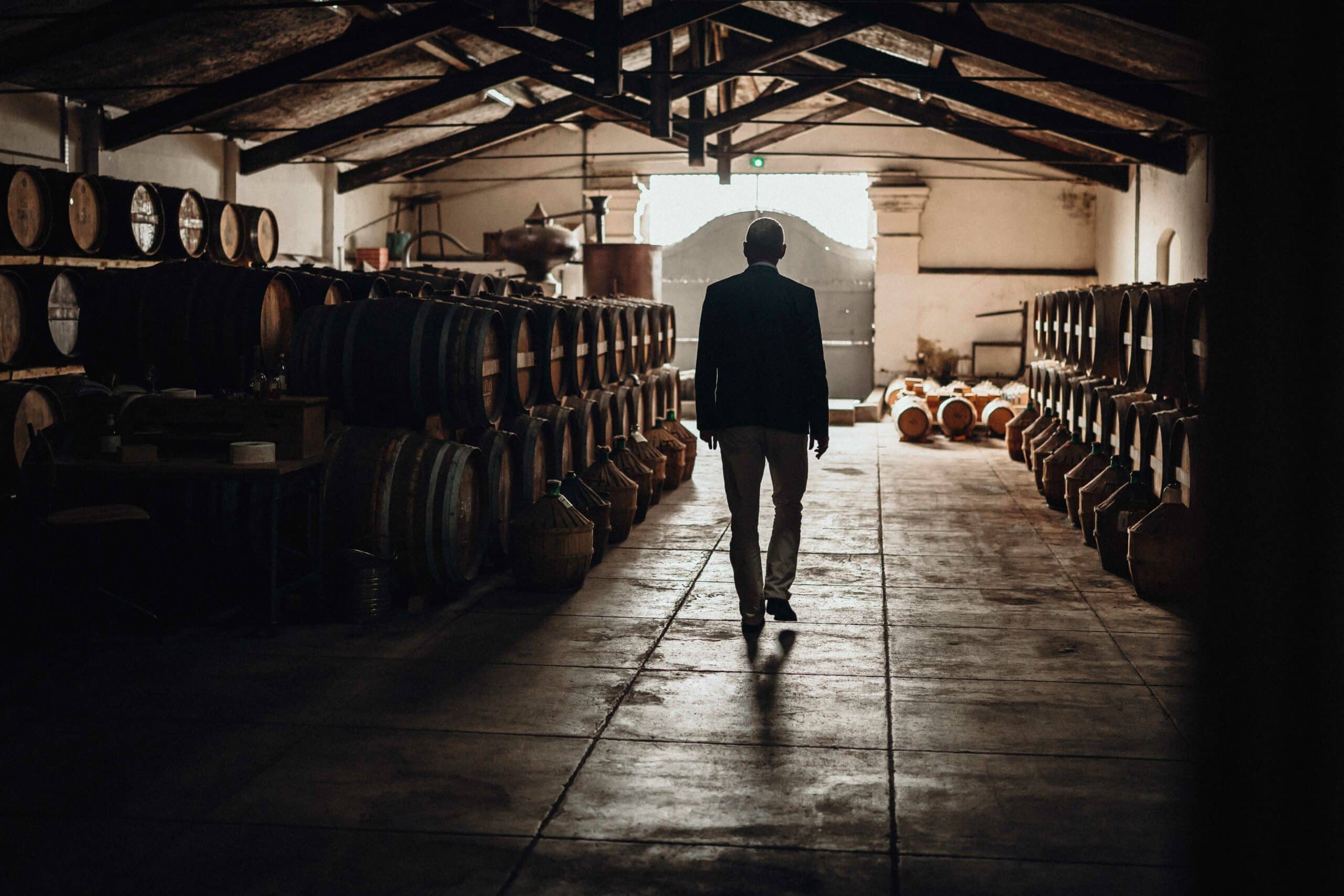 Jean-Phillipe Bergier, cellar master walking in the cellar full of cognac and whisky barrels